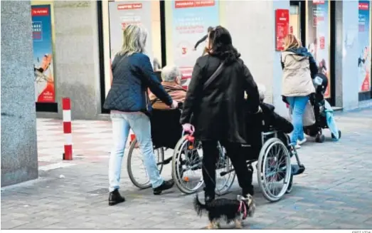  ?? JORDI VIDAL ?? Dos mujeres ayudan a otras dos personas en sillas de ruedas.