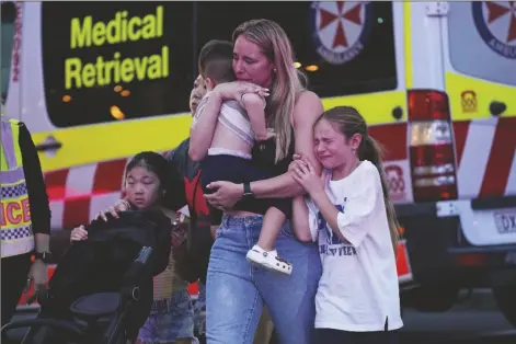  ?? RICK RYCROFT/ASSOCIATED PRESS ?? PEOPLE ARE LED OUT FROM THE WESTFIELD SHOPPING CENTRE, shopping center Saturday before he was fatally shot, police said. where a man stabbed six people to death at the busy Sydney