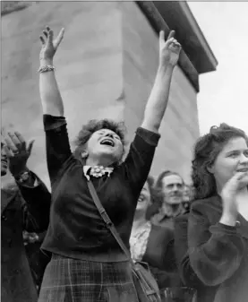  ?? RICHARD BOYER — THE ASSOCIATED PRESS FILE ?? A Parisian girl hold her hands high in the victory sign as American troops pass through Paris, on their way to the front after the French capital was liberated.