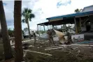  ?? Photograph: Rebecca Blackwell/AP ?? Members of the National Guard assist a storm-damaged business in Horseshoe Beach, Florida, on Thursday.