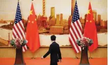  ?? - Reuters file ?? NO CAUSE FOR PANIC: A staff member walks past US and Chinese flags placed for a joint news conference by US Secretary of State Mike Pompeo and Chinese Foreign Minister Wang Yi at the Great Hall of the People in Beijing, China.