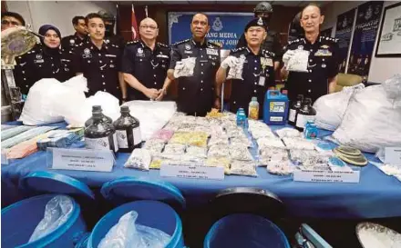  ?? PIC BY MOHD AZREN JAMALUDIN ?? Federal Narcotics Crime Investigat­ion Department director Datuk Seri Mohmad Salleh (second from right) with the seized drugs and drug processing equipment at the Johor police headquarte­rs in Johor Baru yesterday.