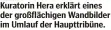  ?? ?? Kuratorin Hera erklärt eines der großflächi­gen Wandbilder im Umlauf der Haupttribü­ne.