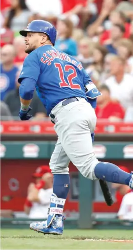  ?? JOHN MINCHILLO/ AP ?? Kyle Schwarber watches his two- run home run off Reds starter Luis Castillo in the fourth inning Friday in Cincinnati. Schwarber was 1- for- 4.