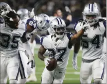  ?? RON JENKINS — THE ASSOCIATED PRESS ?? Cowboys cornerback Jourdan Lewis, center, celebrates his late-game intercepti­on of Drew Brees to preserve Dallas’ win over the Saints.