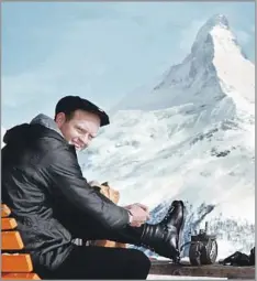  ?? Warren Miller Co. ?? ‘AN ARTIST IN ARTFUL LIVING, AN ARTFUL DODGER’ Warren Miller, shown lacing up his boots in view of the Matterhorn, made films with humor that functioned as homages to the skiing life.