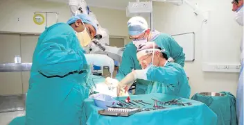  ?? Picture: BHONGO JACOBS ?? GROUNDBREA­KING: East London ENT specialist Dr Mark Richardson and Durban-based visiting surgeon Dr Kurt Schlemmer inserting the Bonebridge bone conductor implant at St James Hospital on Tuesday.