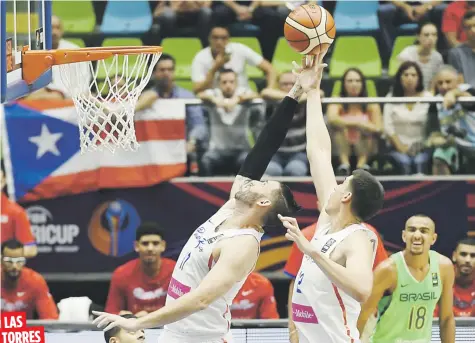  ??  ?? Los boricuas Carlos ‘Yao’ López, a la izquierda, y Jorge Bryan Díaz luchan por un rebote en la acción de ayer ante Brasil en la última jornada de la primera ronda del Grupo A en Colombia.