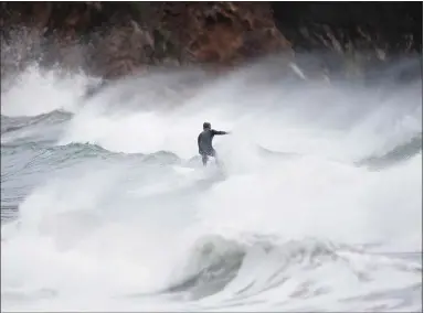  ?? RANDY VAZQUEZ — STAFF PHOTOGRAPH­ER ?? A surfer rides the waves at Pacifica State Beach in Pacifica on Tuesday. High-surf conditions are expected the rest of the week as a series of storms move across the Bay Area.