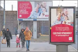  ?? (AP/Dmitri Lovetsky) ?? People walk past posters reading “Do not risk everything that is dear to you. Get vaccinated against coronaviru­s” in St. Petersburg, Russia.