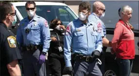  ?? The Canadian Press ?? Police arrest a protester, right, calling on Gov. Roy Cooper to end North Carolina’s stay-athome order on Tuesday in Raleigh, N.C.