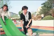  ??  ?? Residents play with their children at one of the “pocket parks” built in the Weifang Hi-tech Industrial Developmen­t Zone.