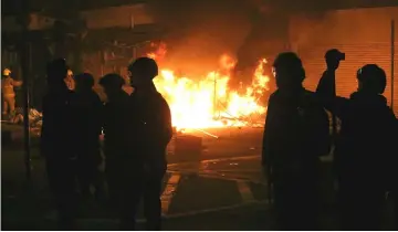  ??  ?? File photo shows Hong Kong riot police silhouette­d as protesters burn debris in the street, as battles erupted after officials tried to move illegal food sellers from an area in Mongkok during the Lunar New Year holiday in Hong Kong. — AFP photo