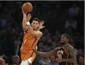  ?? ?? PASS. Phoenix Suns' Devin Booker (1) looks to pass over New York Knicks' Julius Randle (30) during the first half of an NBA basketball game Friday, Nov. 26, 2021, in New York. (AP)