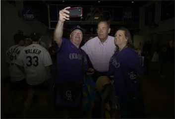  ?? ?? Rockies owner Dick Monfort, center, takes photos with fans while welcoming them at the gate before the home opener on Friday.