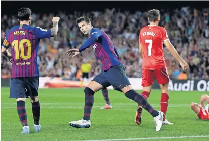  ?? AP ?? Barcelona’s Gerard Pique (centre) celebrates with his teammate Lionel Messi after scoring against Girona. —