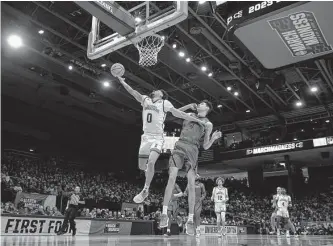  ?? Darron Cummings/associated Press ?? Texas A&M Corpus Christi's Trevian Tennyson (0) drives past Southeast Missouri State's Adam Larson during the Islanders' victory Tuesday, the first NCAA win in school history.