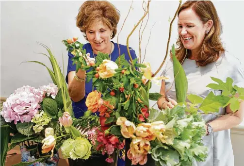  ?? Melissa Phillip photos / Houston Chronicle ?? Carole Bailey, left, and Sara Ledbetter demonstrat­e some of the floral-design techniques that will be on display during the Florescenc­e competitio­n.