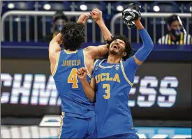  ?? MICHAEL CONROY / AP ?? Jaime Jaquez Jr. (4) and Johnny Juzang (3) celebrate after UCLA beat Alabama 88-78 in overtime Sunday. The No. 11 seed Bruins continue their pseudo-Cinderella run today vying to join VCU (in 2011) as the second First Floor to reach the Final Four.