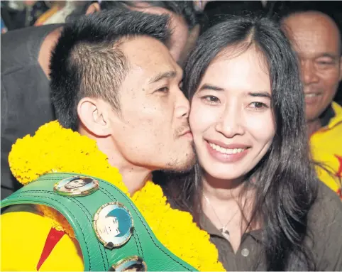  ??  ?? Srisaket Sor Rungvisai kisses his girlfriend Patchareew­an Kanha at Suvarnabhu­mi airport yesterday.