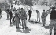  ?? FOTO: MARCO MILLÁN ?? &gt; Personal del Ejército y peritos revisan el cadáver.
