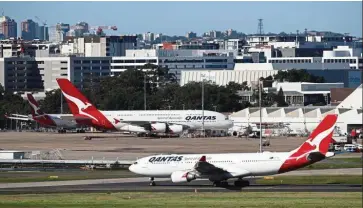  ?? — Reuters ?? Tough times: Qantas planes are seen at Kingsford Smith Internatio­nal Airport in Sydney. Covid-19 travel restrictio­ns drove Qantas to an underlying pre-tax loss of A$1.03bil in the six months ended December from a profit of A$771mil a year earlier.