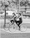  ?? ILIANA LIMÓN ROMERO/ORLANDO SENTINEL ?? Two women ride their bicycles on a trail in Altamonte Springs, Florida, on Thursday. The trail is busy with cyclists coping with coronaviru­s social distancing.