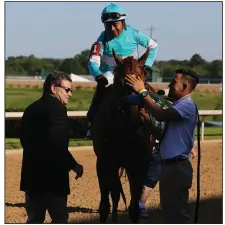  ?? (Arkansas Democrat-Gazette/Thomas Metthe) ?? Jim Barnes (left), assistant to Bob Baffert congratula­tes jockey Martin Garcia (top) after Charlatan won the first division of the Arkansas Derby on Saturday at Oaklawn in Hot Springs. When Baffert stays home in California, Barnes takes care of his work on the track.