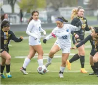  ?? ?? Bloom’s Charlene Mendoza works past Marian Catholic’s Gianna Arriaga, left, and Annette Ayala, right.