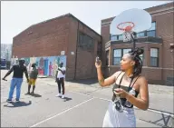  ?? Matthew Brown / Hearst Connecticu­t Media ?? Danielle Jordine, of Stamford, takes videos and photos of the basketball courts at Lathon Wilder Community Center in Stamford on July 19. Full Court Peace, a nonprofit, started a basketball league in the South End to help bridge communitie­s about two years ago. Now they want to revitalize the outdoor basketball courts at the community center. ShyQuinn Dix, a Stamford native, is hoping to push the initiative further and help the community and get further help from developers in the area.