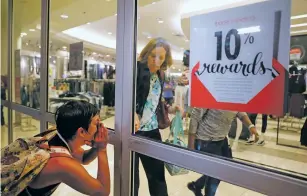  ?? JEFF ROBERSON/THE ASSOCIATED PRESS ?? A protester yells as a woman rushes to close the doors to a department store Saturday in Des Peres, Mo., a suburb of St. Louis.