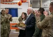  ?? ANDREW HARNIK — THE ASSOCIATED PRESS ?? Vice President Mike Pence and his wife Karen Pence arrive with turkey to serve to troops at Al Asad Air Base, Iraq, on Saturday.