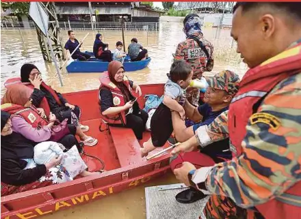  ?? NSTP PIC BY MOHD ADAM ARININ ?? A rescuer carrying a child out of a boat after an evacuation operation in Beaufort, Sabah, yesterday.
