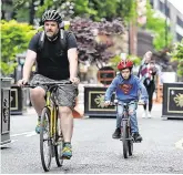  ?? PHOTOS: GARETH CHANEY AND REUTERS ?? On the road: Gardaí at a checkpoint in Ballybough, Dublin yesterday; above, a father and son negotiate Manchester’s Deansgate.