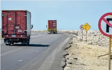  ??  ?? Dos camiones circulan por la vía Barranquil­la-Ciénaga, a la altura del kilómetro 19.