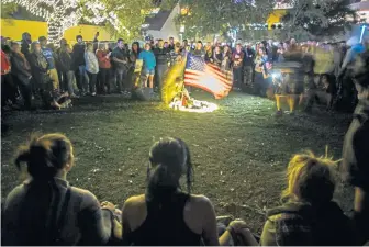  ?? GETTY IMAGES ?? MORE LOSS: People gather around candles and a U.S. flag Thursday during a vigil to pay tribute to the victims of a shooting in Thousand Oaks, Calif.