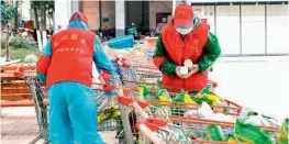  ?? — AFP ?? Community staff members sort food and daily necessitie­s as they prepare to deliver to residents in Wuhan of China’s central Hubei province.