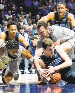 ?? Joshua A. Bickel Associated Press ?? XAVIER FORWARDS Jack Nunge, middle right, and Jerome Hunter, lower left, fight for a loose ball with Villanova guard Chris Arcidiacon­o in the Wildcats’ win.