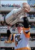  ?? AP PHOTO/GENE J. PUSKAR ?? Pittsburgh Penguins' Sidney Crosby hoists the Stanley Cup while riding in the Stanley Cup victory parade in Pittsburgh, Wednesday.