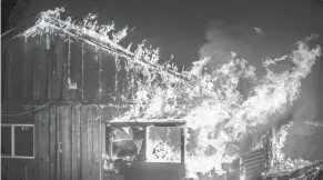  ?? NOAH BERGER/AP ?? Flames fanned by winds shoot from a home as a fire burns through the Berry Creek area of Butte County, Calif., on Wednesday.