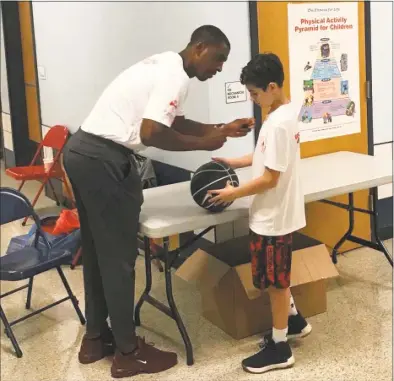  ?? Jeff Jacobs / Hearst Connecticu­t Media ?? Former UConn coach Kevin Ollie signs an autograph during a charity event in Gales Ferry on Sunday.