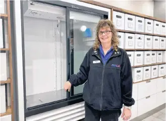  ??  ?? Yarmouth NSLC sales clerk Liz Wilson stands next to an empty cooler that will soon be full of cannabis-infused drinks.