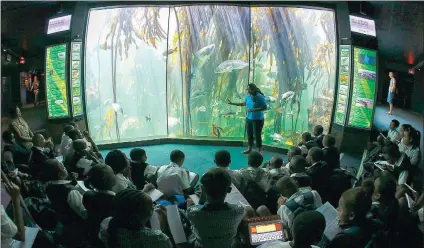  ?? Picture: EPA/NIC BOTHMA ?? AWARENESS: A guide at the Two Oceans Aquarium educates schoolchil­dren in front of the Kelp Forest exhibit in Cape Town, in February.