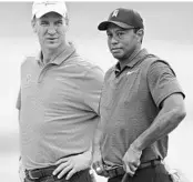 ?? DAVID DERMER/ASSOCIATED PRESS ?? Peyton Manning and Tiger Woods chat at the 11th hole during the Memorial pro-am on Wednesday in Dublin, Ohio.