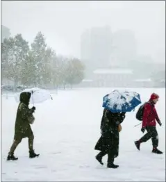  ?? ASSOCIATED PRESS ?? People walk during a snow storm in view of Independen­ce Hall in Philadelph­ia, Thursday.