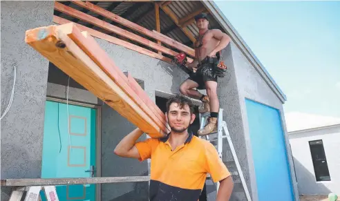  ?? Picture: STEWART McLEAN ?? LONG HOURS: Carpenters Dean Gatto and Ryan Davies at work on a new home at Smithfield Village.