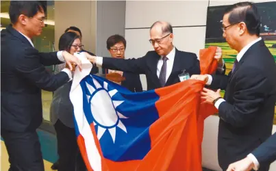  ??  ?? 駐巴拿馬大使曹立傑（右一）17日返台，帶回在巴國所降下的中­華民國國旗，並交給外交部長李大維（右二）。 （中央社）