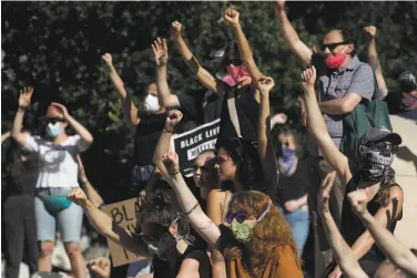  ?? Jeff Chiu / Associated Press ?? Protesters raise their hands Thursday during an Oakland rally against police brutality, racism and the death of George Floyd at the hands of Minneapoli­s police officers over the Memorial Day weekend.