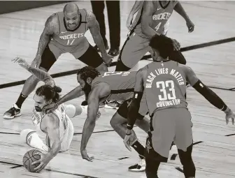  ?? Pool / Getty Images ?? The Rockets’ James Harden, right, and the Thunder’s Steven Adams battle for the ball during the third quarter of Game 2 on Thursday. Tenacious defense again keyed the Rockets’ victory.