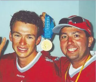  ??  ?? Canadian triathlete Simon Whitfield, left, and coach Barrie Shepley celebrate the gold medal Whitfield won in triathlon's 2000 Olympic debut in Sydney. Shepley is now the worlds longest-serving triathlon TV commentato­r.
